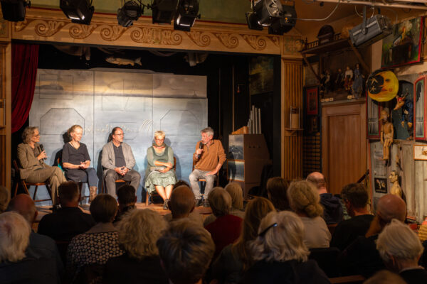 Auf der Bühne des Figurentheaters Homunkulus diskutieren (von rechts): Hasso Spode, Marion Magas, Burkhard Bley und Christiane Wolff, Liane von Billerbeck moderiert das Gespräch, 21. September 2025 (Christian Faludi/GEDG)