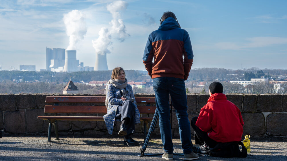 Grit Lemke im Interview im Stadtpark von Spremberg, den Industriekomplex Schwarze Pumpe im Rücken, 26. Februar 2026 (Christian Faludi /GEDG)